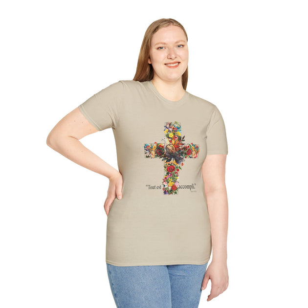Une femme porte un t-shirt beige orné d'une croix fleurie et de l'inscription Tout est accompli.
