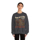 Une femme porte un sweat-shirt gris foncé avec une illustration de paysage et un message religieux.